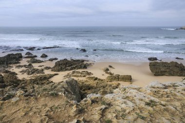 Pessegueiro Adası plajı Porto Covo, Alentejo, Portekiz 'de bulutlu ve rüzgarlı bir günde
