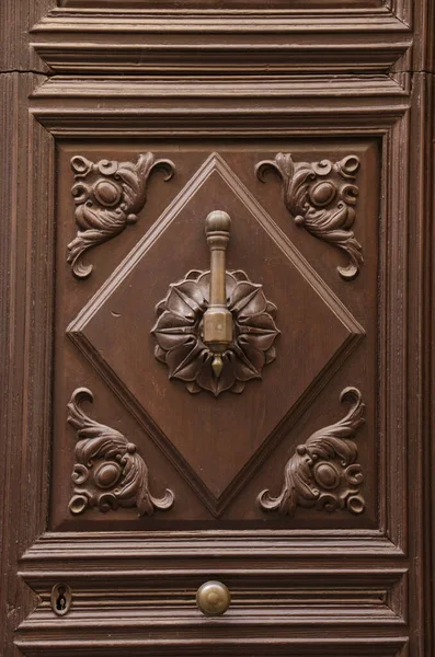 Old wooden carved door and vintage door knocker in Spain