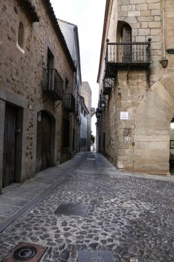 Caceres, Extremadura, İspanya - 23 Ekim 2023: Eski İspanya 'nın Caceres kentindeki tarihi taş evlerin kaldırımları ve cepheleri