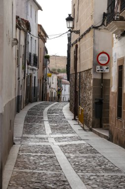 Caceres, Extremadura, İspanya - 23 Ekim 2023: Eski İspanya 'nın Caceres kentindeki tarihi taş evlerin kaldırımları ve cepheleri
