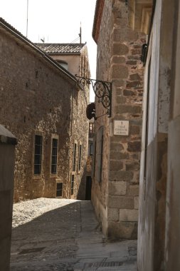 Caceres, Extremadura, İspanya - 21 Ekim 2023: İspanya 'nın eski Caceres kentindeki tarihi taş evlerin kaldırımları ve cepheleri