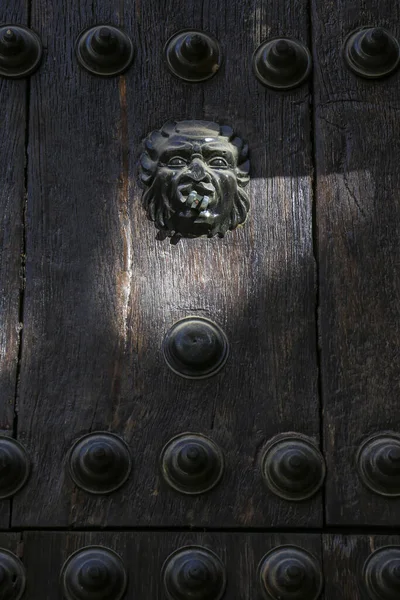 Ronda, Malaga 'da demir döşeme ve klasik kapı tokmağı olan güzel eski ahşap kapı.