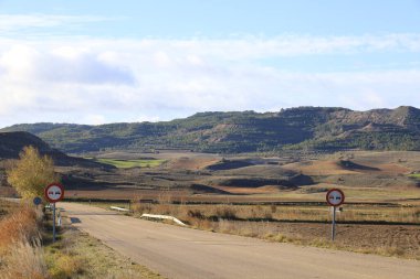 İspanya 'da trafik işaretli ıssız bir yol. Arkaplanda dağlar
