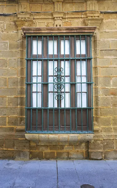 Typical andalusian house window with wrought iron grill in Rota city