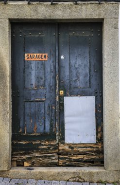 Elvas, Portekiz- 12 Ekim 2023 Portekiz 'de eski ve hasarlı ahşap bir garaj kapısı