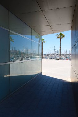 Alicante, İspanya - 20 Mart 2024: Soyut bina yapısı ve güneşli bir yaz gününde Alicante 'nin deniz kulübünde demirlemiş tekneler