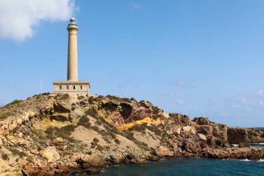 Neoklasik Cabo de Palos deniz feneri ve Cala Fria plajı Yazın güneşli bir gününde