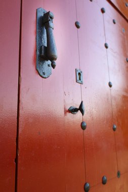 Madrid 'de demir detaylar ve klasik kapı tokmakları olan eski kırmızı kapı.