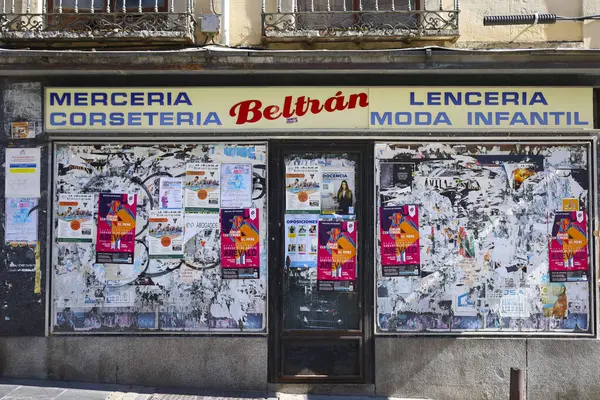 stock image Avila, Castilla y Leon, Spain- August 17, 2024: Closed corset and fashion shop filled with colorful advertising stickers in the old town of Avila