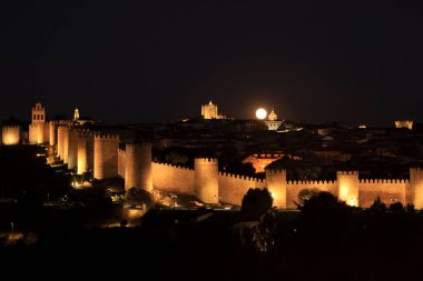 Avila şehrinin panoramik manzarası, yazın dolunay varken gece duvar ve kale.