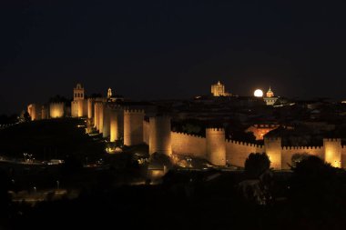 Avila şehrinin panoramik manzarası, yazın dolunay varken gece duvar ve kale.