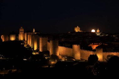 Avila şehrinin panoramik manzarası, yazın dolunay varken gece duvar ve kale.