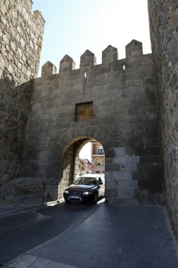 Avila, Castilla y Leon, İspanya - 18 Ağustos 2024: araba El Puente kapısından ve Avila şehrinin duvarlarından geçiyor