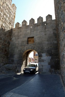 Avila, Castilla y Leon, İspanya - 18 Ağustos 2024: araba El Puente kapısından ve Avila şehrinin duvarlarından geçiyor