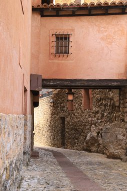 İspanya 'nın Teruel kasabasında eski ahşap kirişler ve klasik sokak lambalarıyla dar bir geçit.
