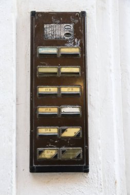 Valencia, İspanya... 27 Aralık 2024: Beyaz duvarda eski kapı zili plakası