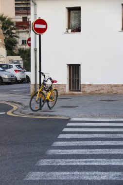 Valencia, Spain- December 18, 2024: Vintage bicycle leaning on traffic signal on the street in The Cabanyal neighborhood in Valencia city clipart