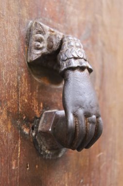 Paslı kapı tokmağı. İspanya 'daki eski kahverengi ahşap kapıya el şeklinde.