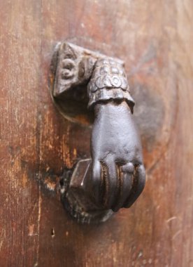 Paslı kapı tokmağı. İspanya 'daki eski kahverengi ahşap kapıya el şeklinde.