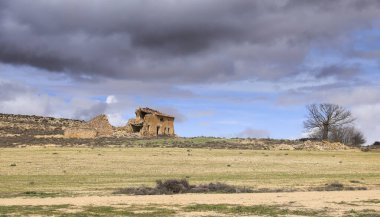 İspanya 'nın Castilla La Mancha bölgesinde ekili araziyle çevrili terk edilmiş taş ev.