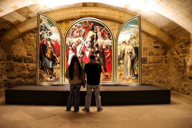Segovia, Castilla y Leon, İspanya - 5 Nisan 2025: İnsanlar Segovia Katedrali 'nin Resim Salonu' nda Ambrosius Benson 'un The Descent' in Üçlemesi 'ne bakıyorlar.