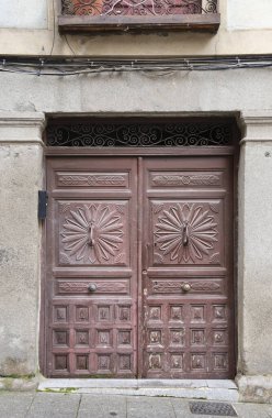 İspanya, Segovia 'da işlenmiş demir detayları olan eski ahşap bir kapı.