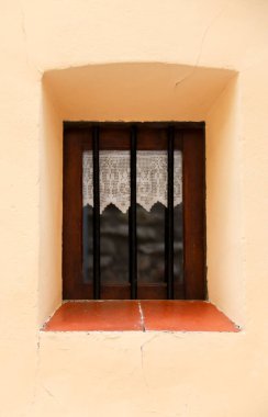 İspanya, Castellon 'daki Morella kasabasında beyaz örgü perdeli küçük bir pencere.