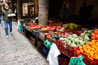 Morella, Castellon, İspanya... 18 Nisan 2025: Blasco de Alagon caddesinde meyva ve sebzelerle dolu market tezgahları ve Morella şehrindeki tarihi eski evler, tepenin üstünde yer alan bir şehir.