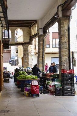 Morella, Castellon, İspanya... 18 Nisan 2025: Blasco de Alagon caddesinde meyva ve sebzelerle dolu market tezgahları ve Morella şehrindeki tarihi eski evler, tepenin üstünde yer alan bir şehir.