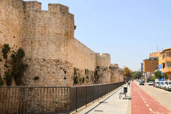 Denia, Alicante, İspanya - 18 Mayıs 2025 Denia Kalesi 'ni çevreleyen duvarlar bir bisiklet yolunun yanında.