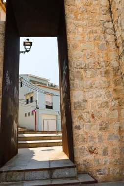 Denia, Alicante, İspanya - 18 Mayıs 2025: Eski İspanya 'nın Alicante kentindeki taş duvarda modern kapılı geçit