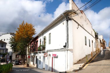 Denia, Alicante, İspanya - 18 Mayıs 2025: Eski Denia kasabasında Les Roques mahallesinde güzel beyaz boyalı evleri olan dar sokaklar