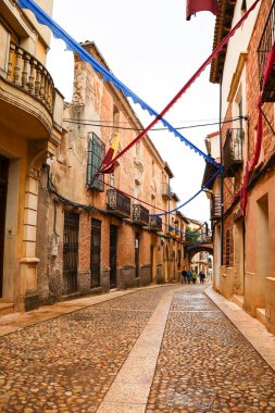 Alcaraz, Albacete, İspanya - 2 Mayıs 2025: Alfonsi Ortaçağ pazarını kutlayan, çelenklerle süslenmiş eski Alcaraz kasabası