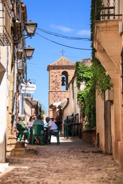 Alcaraz, Albacete, İspanya... 7 Mayıs 2025, Alcaraz kasabasında güzel evleri olan Dar Sokak. Arka planda San Miguel kilisesinin çan kulesi var..