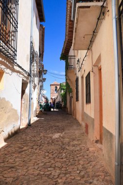 Alcaraz, Albacete, İspanya... 7 Mayıs 2025, Alcaraz kasabasında güzel evleri olan Dar Sokak. Arka planda San Miguel kilisesinin çan kulesi var..