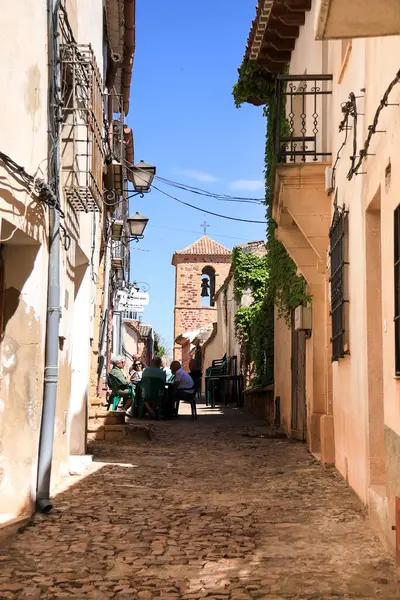 Alcaraz, Albacete, İspanya... 7 Mayıs 2025, Alcaraz kasabasında güzel evleri olan Dar Sokak. Arka planda San Miguel kilisesinin çan kulesi var..