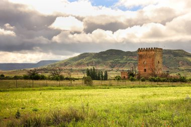Gorgoji kulesi Sierra de Alcaraz, Albacete, İspanya 'da yeşil çayırlar ve dağlarla çevrilidir.