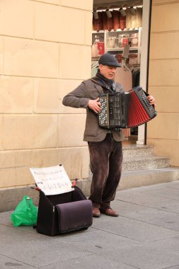 Segovia, Castilla y Leon, İspanya - 5 Nisan 2025: Eski Segovia şehrinin sokaklarında dilenci ve akordeon çalan adam