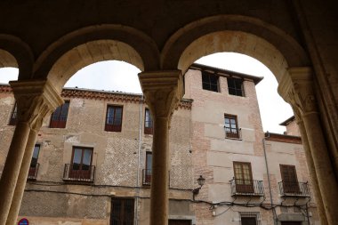 İspanya 'nın Castilla y Leon kentindeki eski Segovia şehrindeki Santisima Trinidad Kilisesi' nden Atrium. Del Campo ailesinin sarayı arka planda..