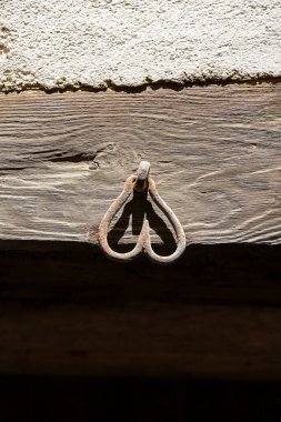 Tahta kirişte ters dönmüş kalp şeklinde pranga