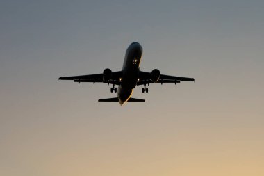 İspanya, Alicante 'de gün batımında gökyüzü açık bir şekilde havaalanına yaklaşan uçak.