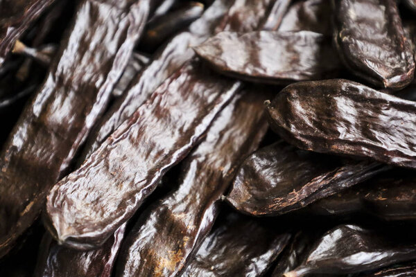 Carob pods background. Fruit of the carob tree, Ceratonia Siliqua