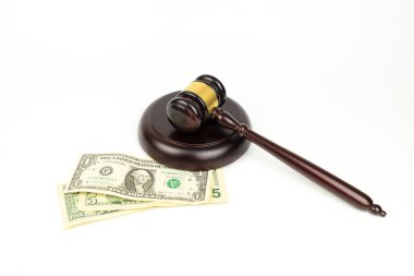 Adalet tokmağı beyaz arka planda dolar banknotlarının yanında. Finans yasalarının sembolü