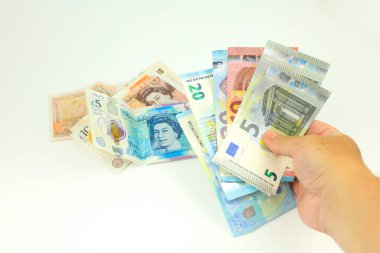 Beyaz arka planda sterlin ve avro banknotları el ele tutuşuyor