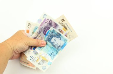 Beyaz arka planda el ele tutuşan sterlin banknotları