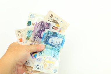 Beyaz arka planda el ele tutuşan sterlin banknotları