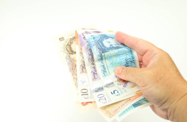 Beyaz arka planda el ele tutuşan sterlin banknotları