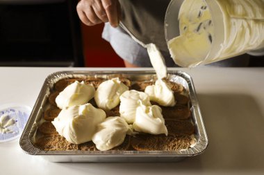 Kadın mutfakta Tiramisu tatlısı yapıyor.