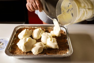 Kadın mutfakta Tiramisu tatlısı yapıyor.