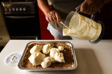 Kadın mutfakta Tiramisu tatlısı yapıyor.